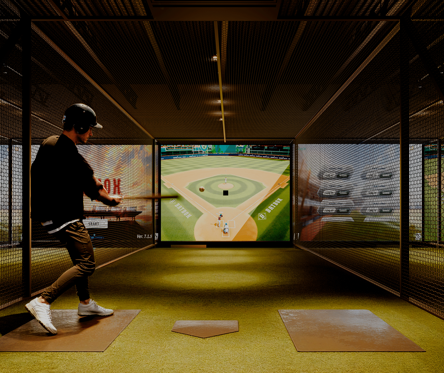 A young man hitting a baseball in a Batbox simulator.