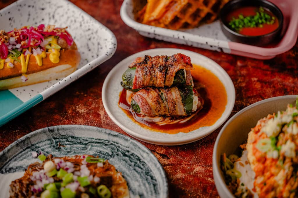 RC3-January25-FullAlbum-74 Charred and pickled jalapeños, stuffed with burnt ends, cream cheese, and herbs, wrapped in applewood-smoked bacon and topped with marshmallow BBQ sauce and Alabama white sauce.